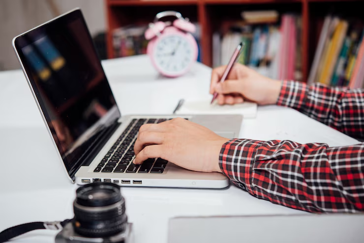 Gentleman taking notes during an online course