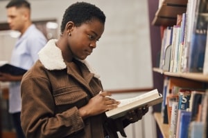 Focused African Student Girl Reading Book at Library