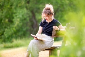 Girl Stting Alone on Bench Reading Book