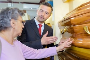 Funeral Director Showing Woman A Coffin