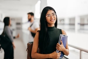 Girl Student with Backpack Carrying Books in College