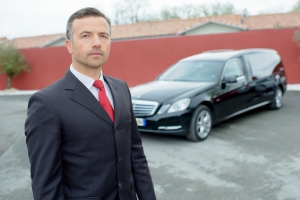 Funeral Director Standing in Front of Hearse