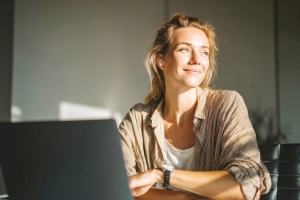 Smiling Corporate Woman Thinking about Career Change Into Funeral Service at Her Desk
