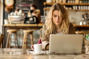 Mortuary Science Student Working on Laptop at a Cozy Cafe