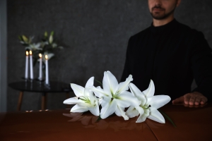 Funeral Home Manager Near Casket with White Lilies