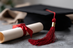 Graduation Cap with Rolled Degree on Table