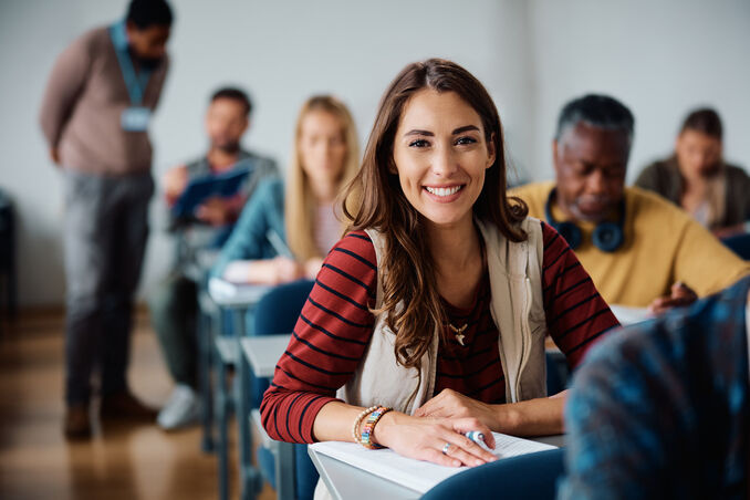 Happy female student learning in classroom