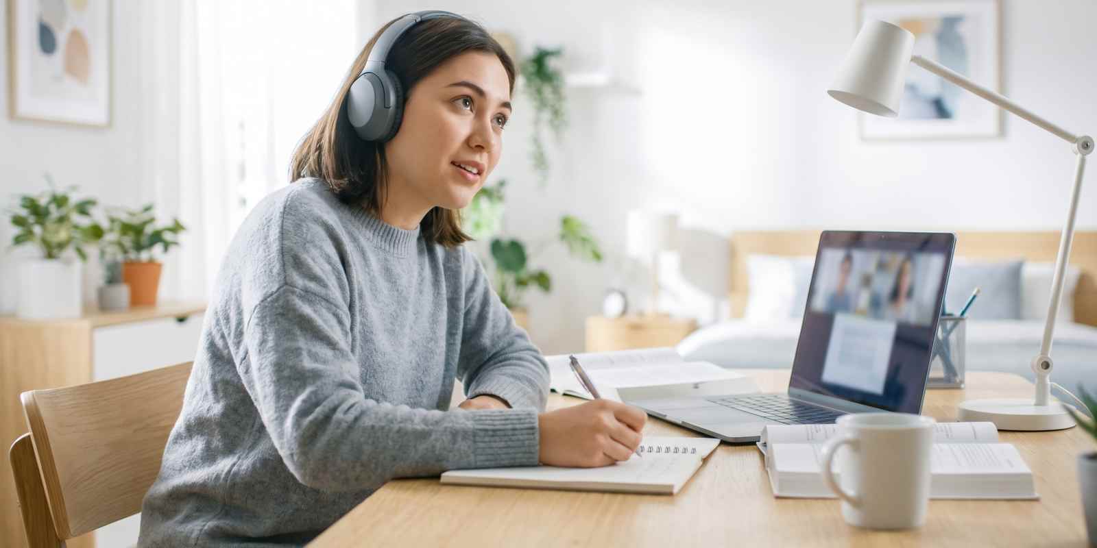 Mortuary Science Student Attending Online Class From Home Using Laptop and Headphones