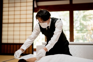 An Embalmer Wearing a Mask and Gloves to Avoid Infection During Funeral Preparation