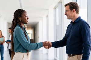 Female Mortuary Science Student Shaking Hand with Industry Professional in College Campus